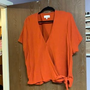 Burnt orange wrap style top with tie on side.